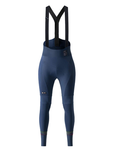 A pair of navy blue women's long cycling bib tights with black shoulder straps. The fabric shows various textures with darker shades of navy, particularly around the thigh area. The brand 'GOBIK' is subtly placed on the left thigh.
