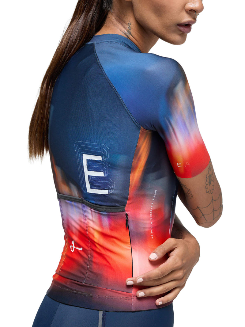 Close-up of the Givelo Essentials Chaos cycling jersey with vibrant red to blue gradient and text detail.