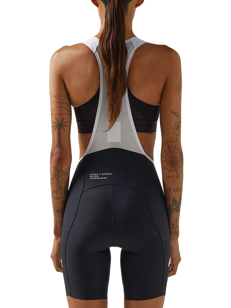 Rear view of a woman wearing black Givelo HD Pro Bib Shorts with white shoulder straps, emphasizing the shorts&