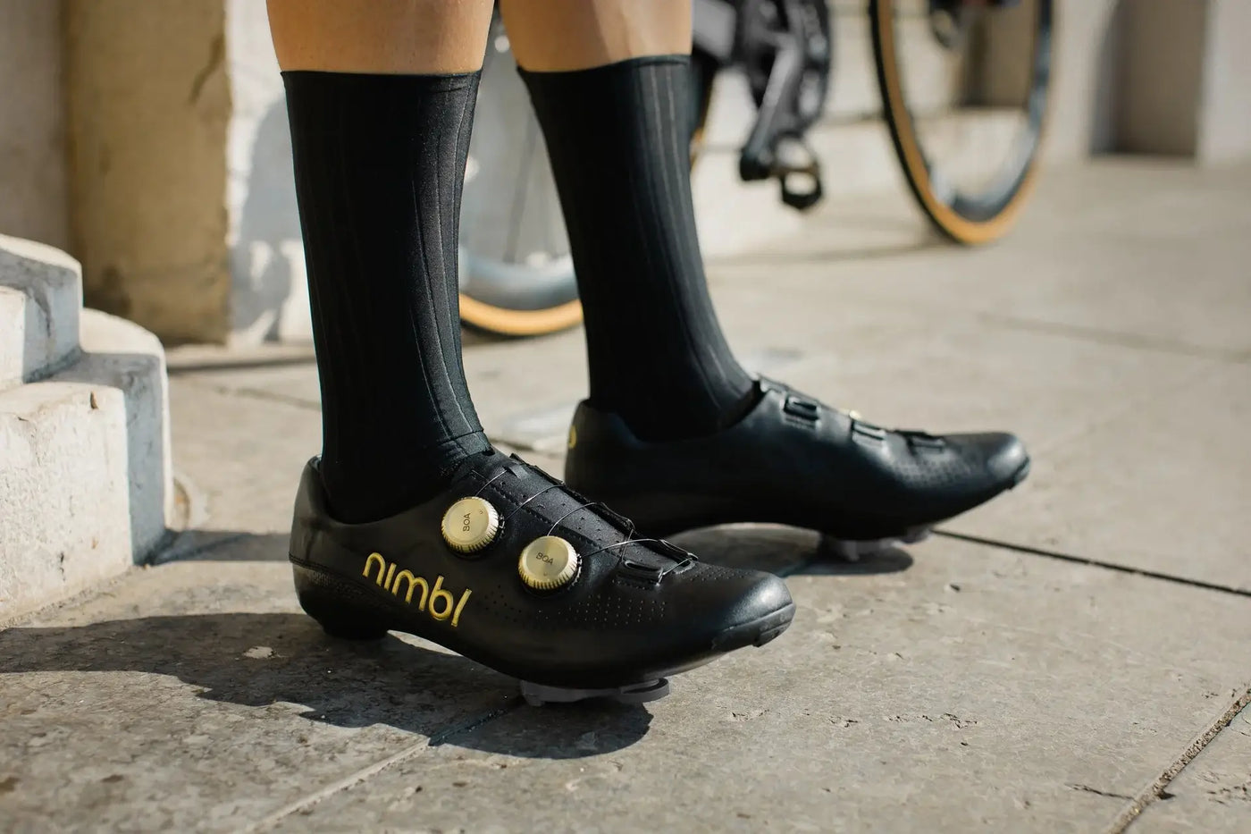 Male Cyclist wearing Nimbl Ultimate leather cycling shoes in black with gold lettering and BOAs