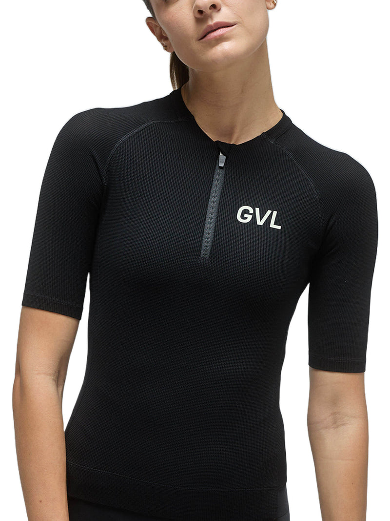 Front view of a woman wearing a black Givelo Modern Classic jersey, demonstrating the half-zip feature, snug fit, and the &