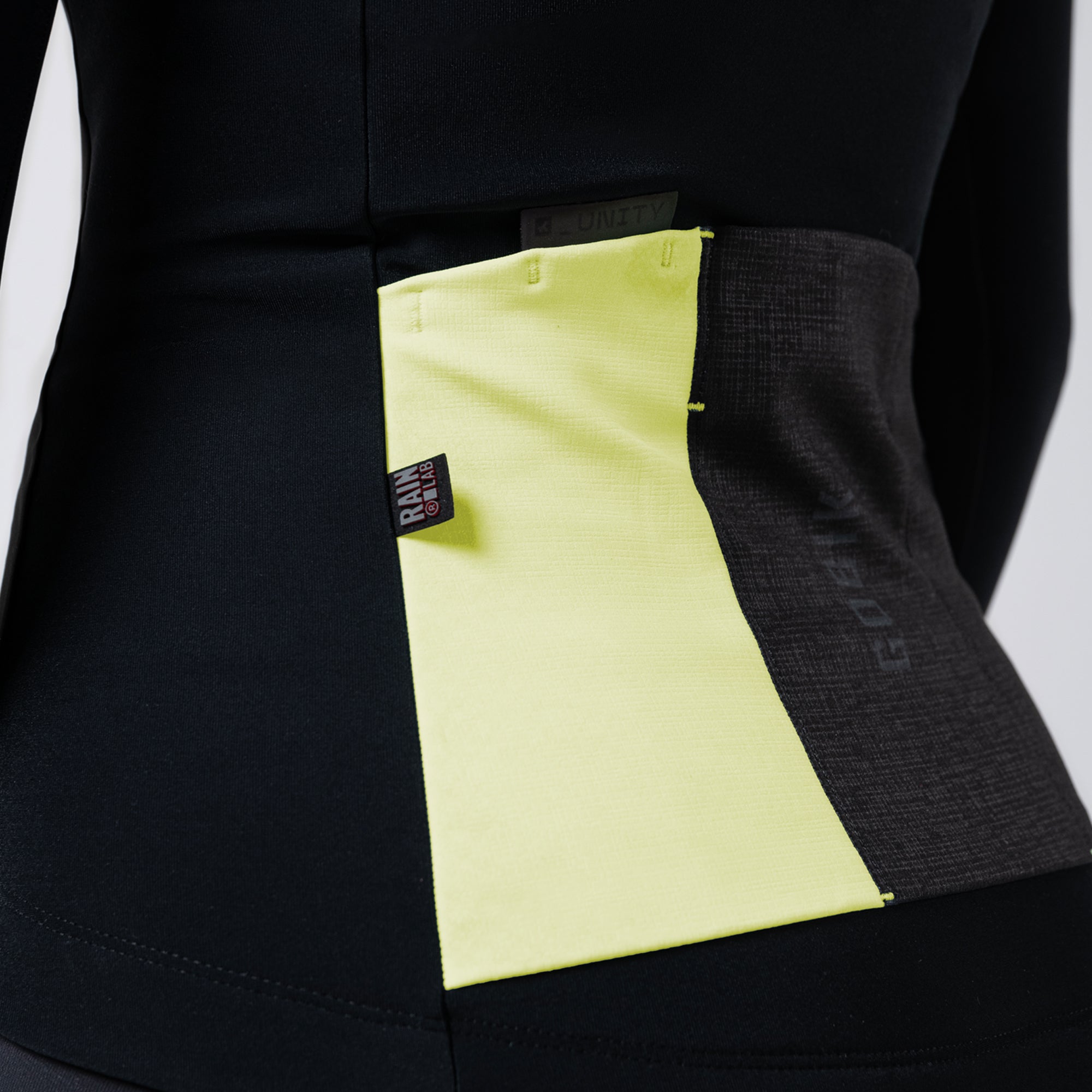 Close-up of GOBIK Mist Blend 2.0 Jacket - Women's rear pocket detail in high-visibility yellow and black fabric panel