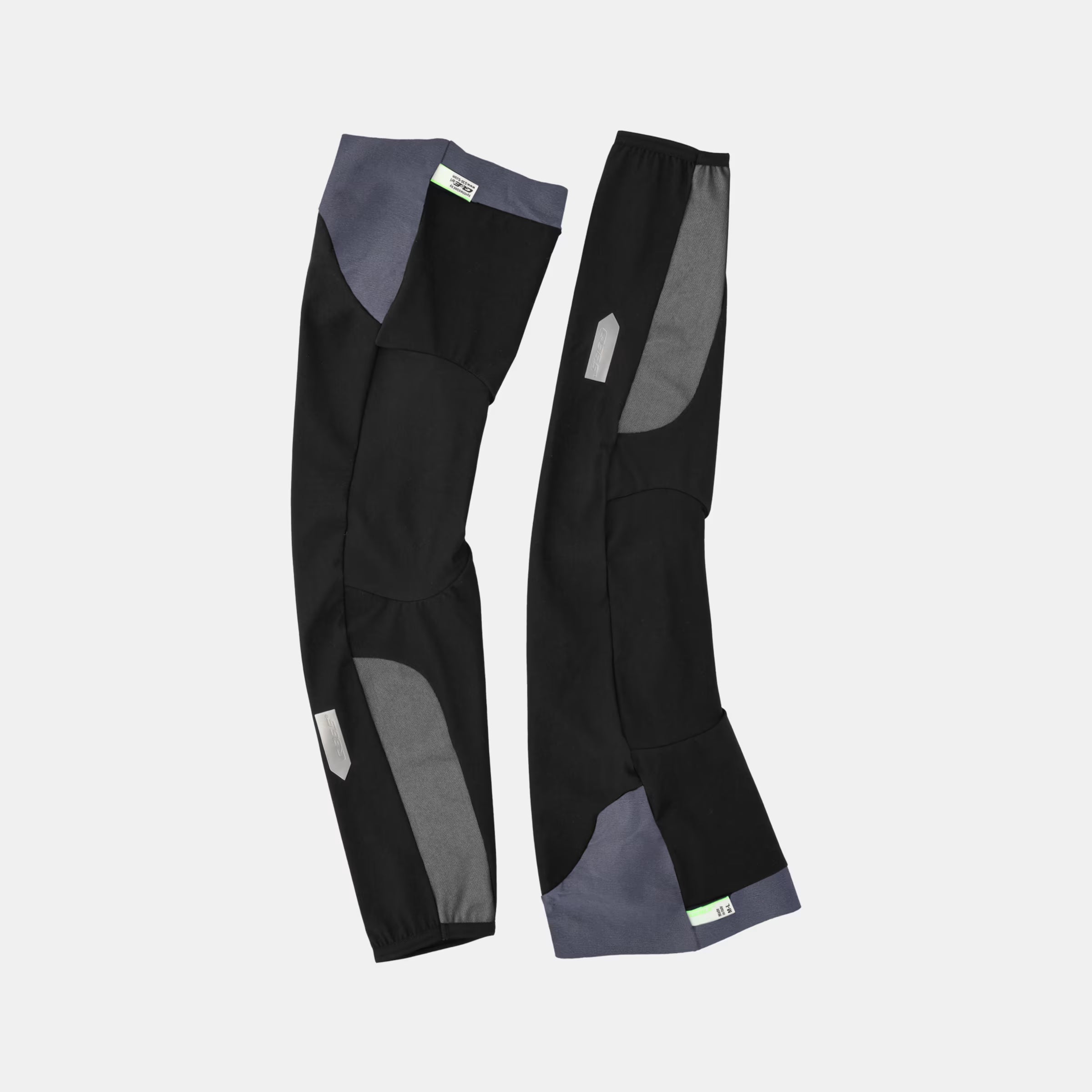Pair of Q36.5 WoolF Leg Warmer - Black showing dual-layer merino blend fabric and reflective details against white background