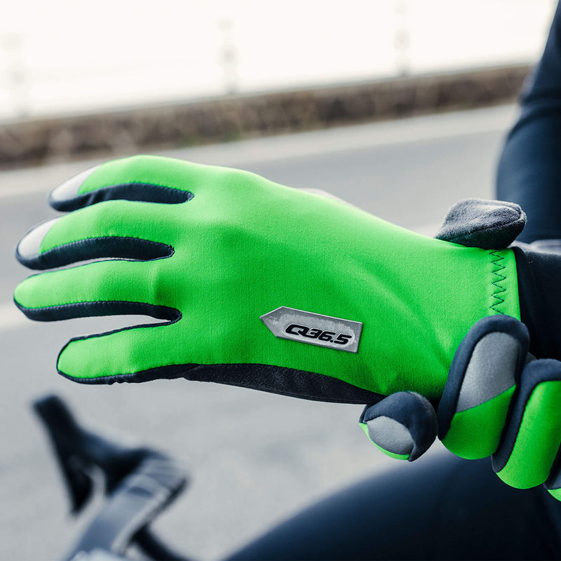 Cyclist showcasing the bright green Q36.5 Hybrid Que X Gloves while riding.