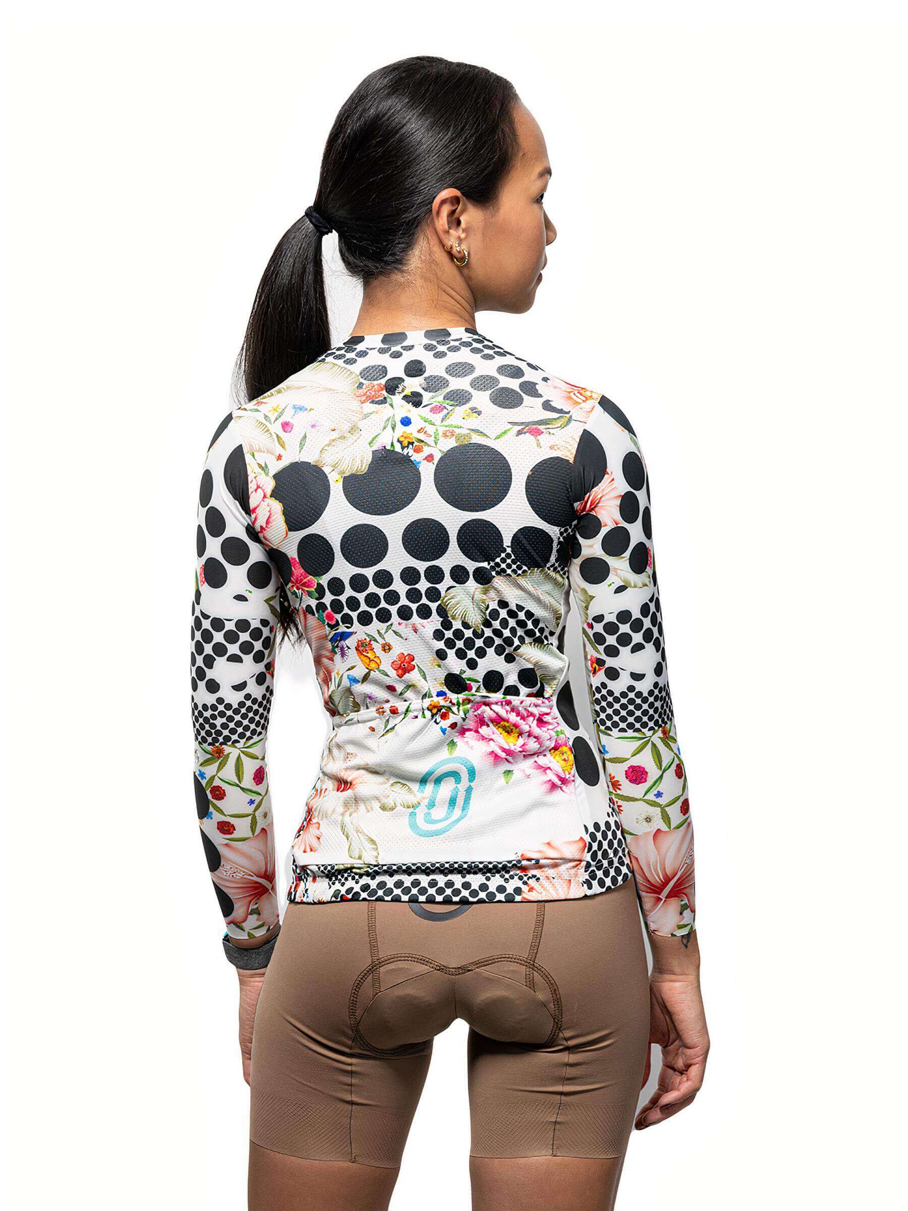 Back view of woman wearing Ostroy Omloop White Lightweight Long-Sleeve Jersey - Women's with floral and polka dot design