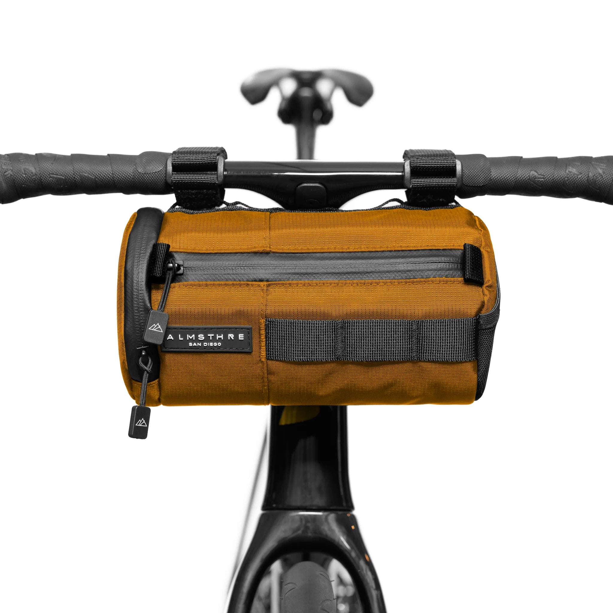 ALMSTHRE Signature Bar Bag mounted on bike handlebars in brown with zippered front pocket and secure straps