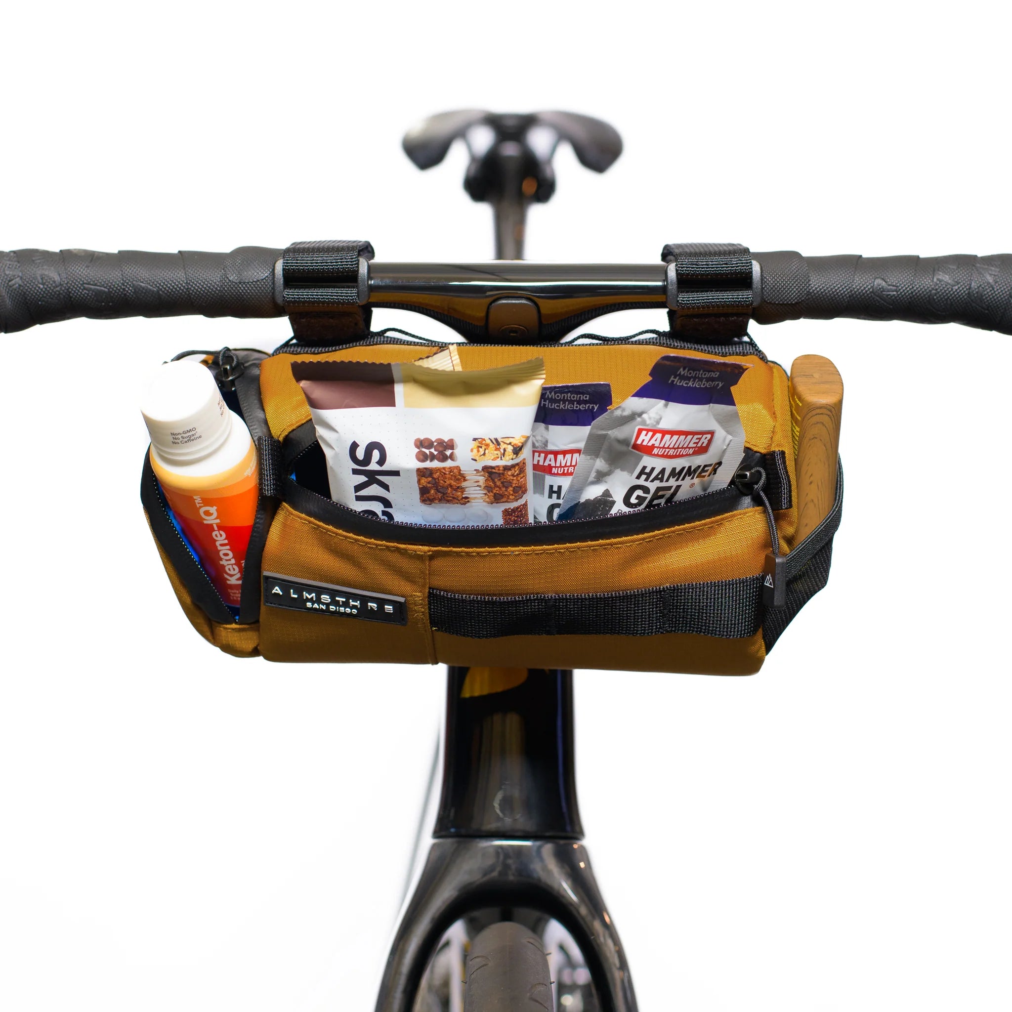 ALMSTHRE Signature Bar Bag mounted on bike handlebar loaded with snacks and energy gels for easy access during rides