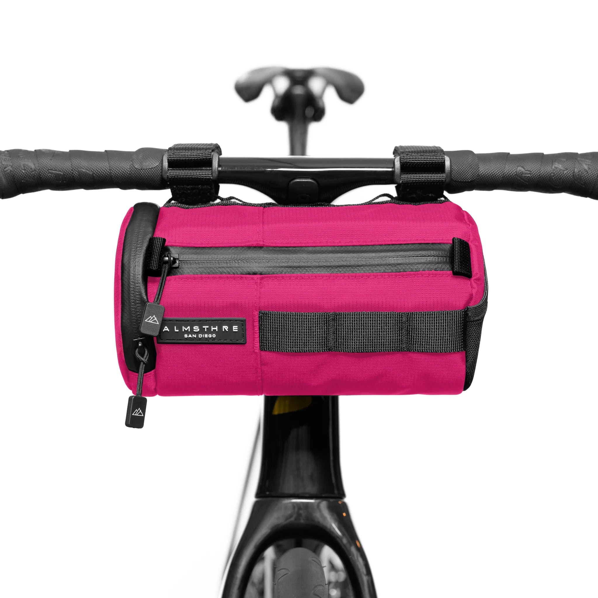 ALMSTHRE Signature Bar Bag in bright pink mounted on bike handlebars showing front zipper pocket and sturdy straps