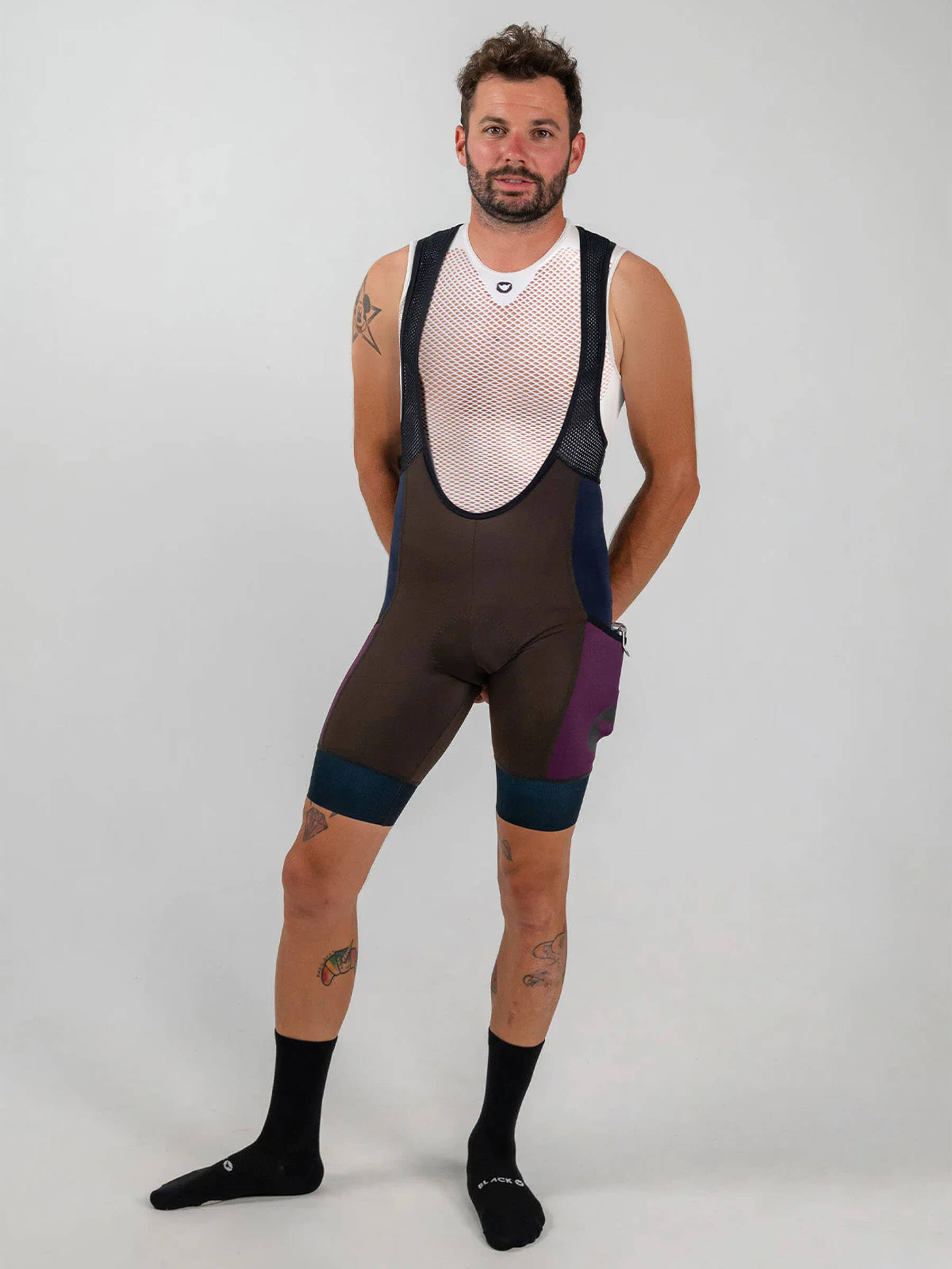 Man wearing Black Sheep Cycling ADV Cargo Bib Shorts - Men's standing against plain background with hands behind back