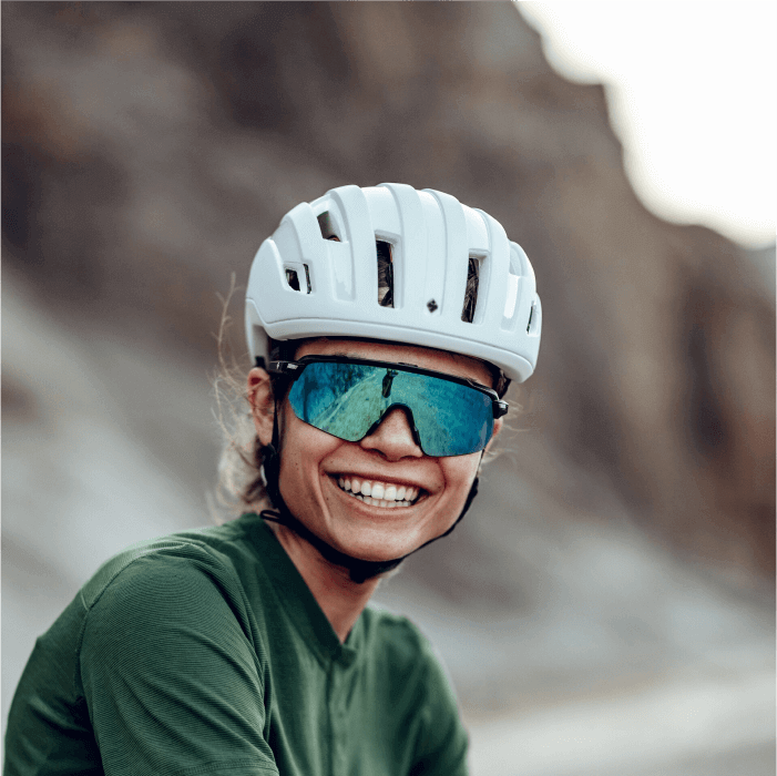 women wearing a sweet protection mips outrider helmet in matte white, and the shinobi RIG reflect sunglasses in emerald and matte crystal storm
