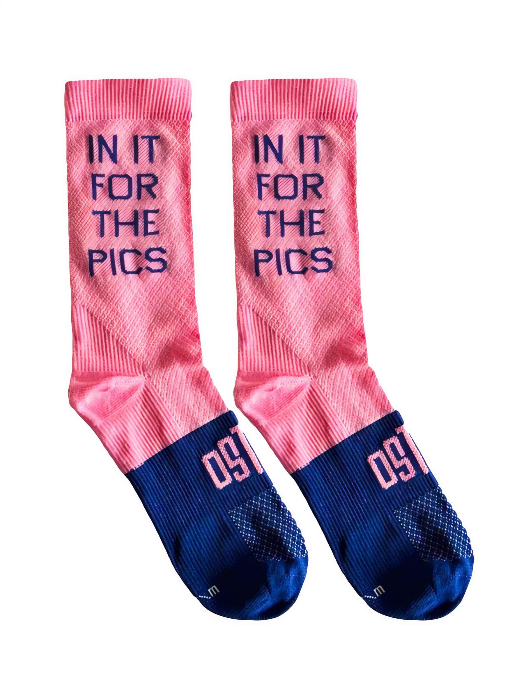 Pair of Ostroy In It For The Pics Socks in pink and navy with bold text and reinforced footbed for cycling performance
