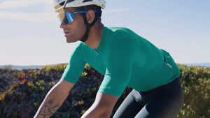 man wearing a black sheep cycling TEAM essentials jersey in storm green, black sheep bib in black, roadkit