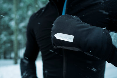 Close-up of a cyclist's hand showing the grip and fabric detail of  Q36.5's black winter glove.