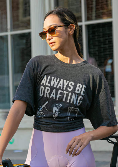Woman in sunglasses wearing a grey "Always Be Drafting" tee shirt.