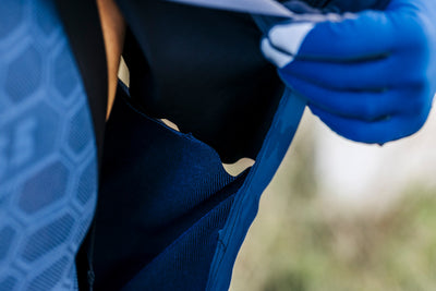 Close-up on the side pocket of the blue Q36.5 Bat Shell Jersey, illustrating the accessible ventilation pockets for temperature regulation.