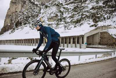 Cyclist pedaling in Q36.5 Winter Bib Tights, highlighting ergonomic design.
