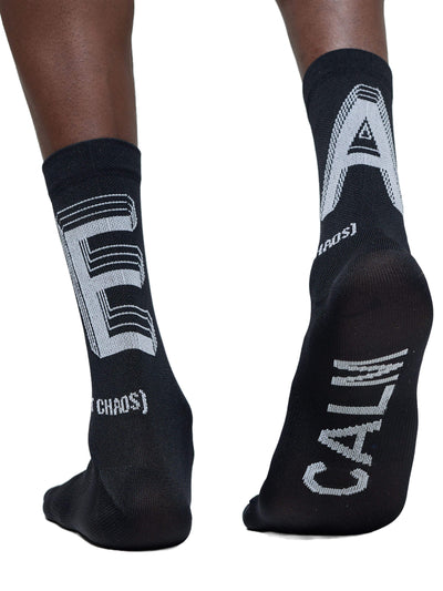 The back view of the black Givelo G-Socks, Chaos model, with an emphasis on the ribbed texture for calf support and the contrasting white "Chaos" and logo on the back.