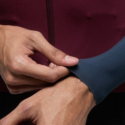 A close-up on the wrist of a rider wearing the Givelo Modern Classic long sleeve jersey, highlighting the snug fit and the transition from the burgundy sleeve to the grey panel.