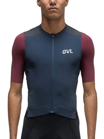 A person is wearing the Givelo Modern Classic Short Sleeve Jersey in a navy blue color with maroon side panels. The close-up front view showcases the jersey's quality Italian fabric, the 'GVL' logo on the chest, and the tonal cam-lock zipper for easy ventilation.