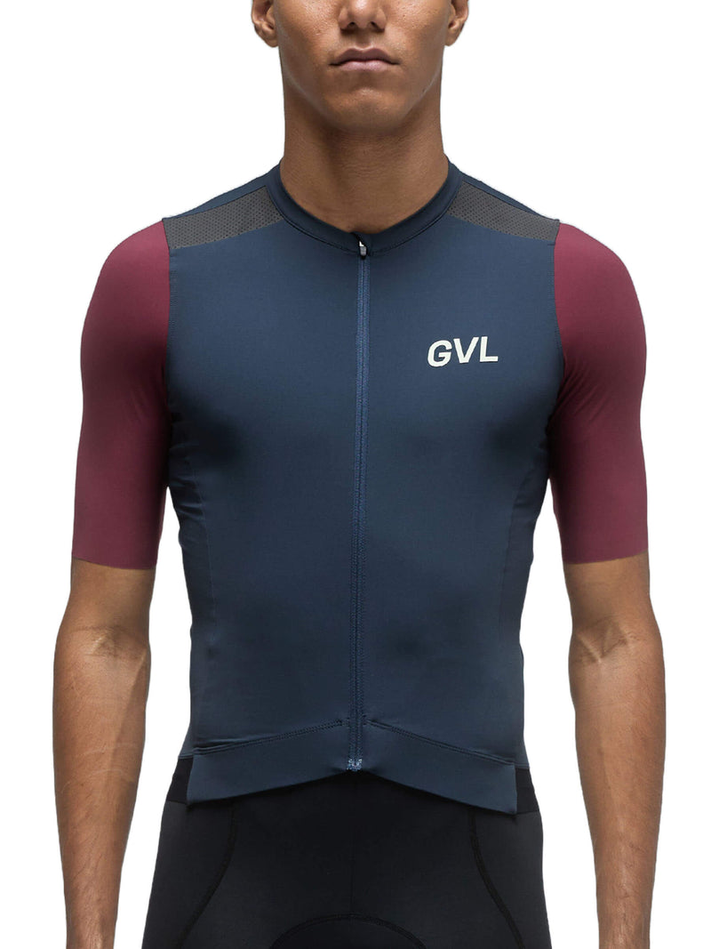 A person is wearing the Givelo Modern Classic Short Sleeve Jersey in a navy blue color with maroon side panels. The close-up front view showcases the jersey&