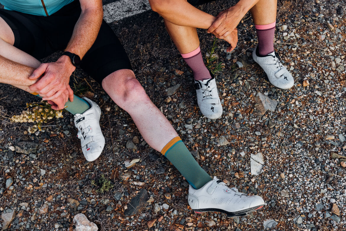 two people wearing the Isadore climber's socks in green and pink, roadkit 