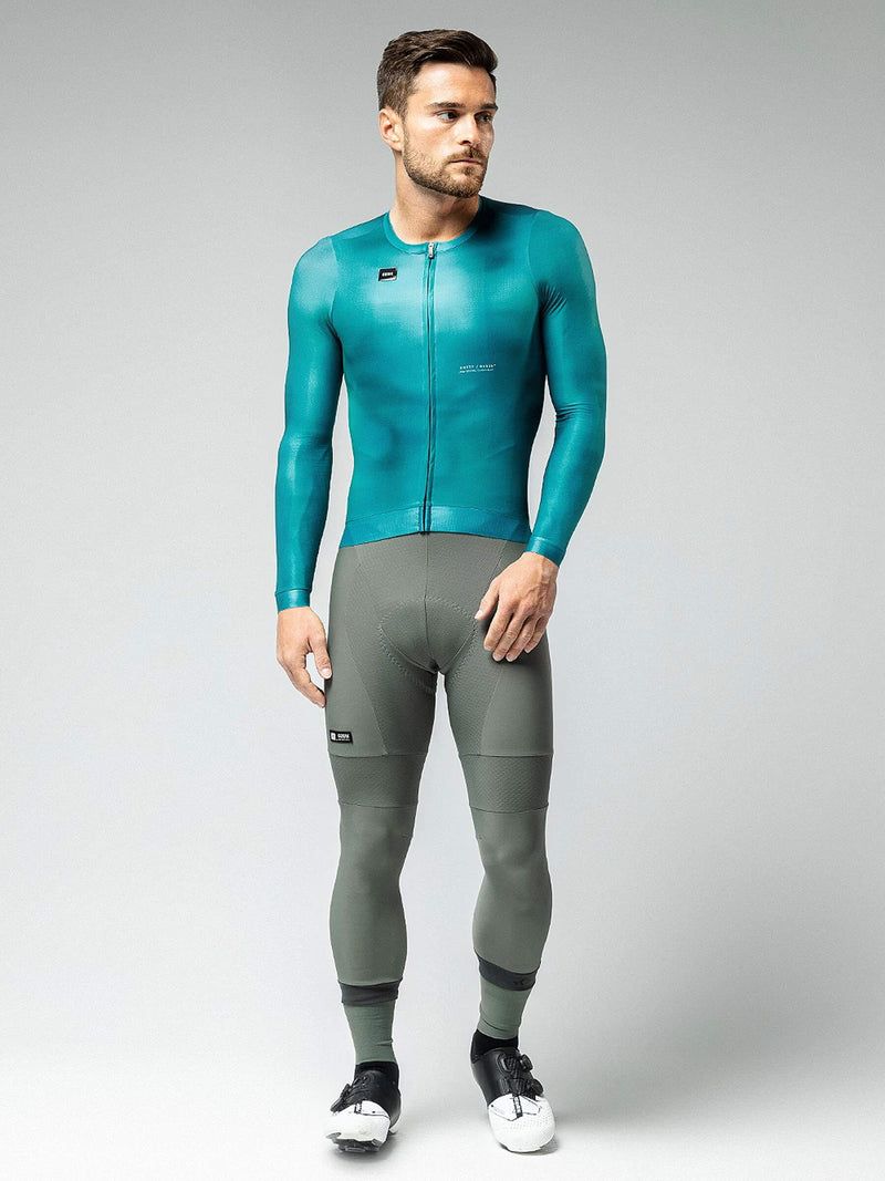 Male cyclist modeling the teal GOBIK CX Pro 2.0 jersey with snug sleeves and back pockets.