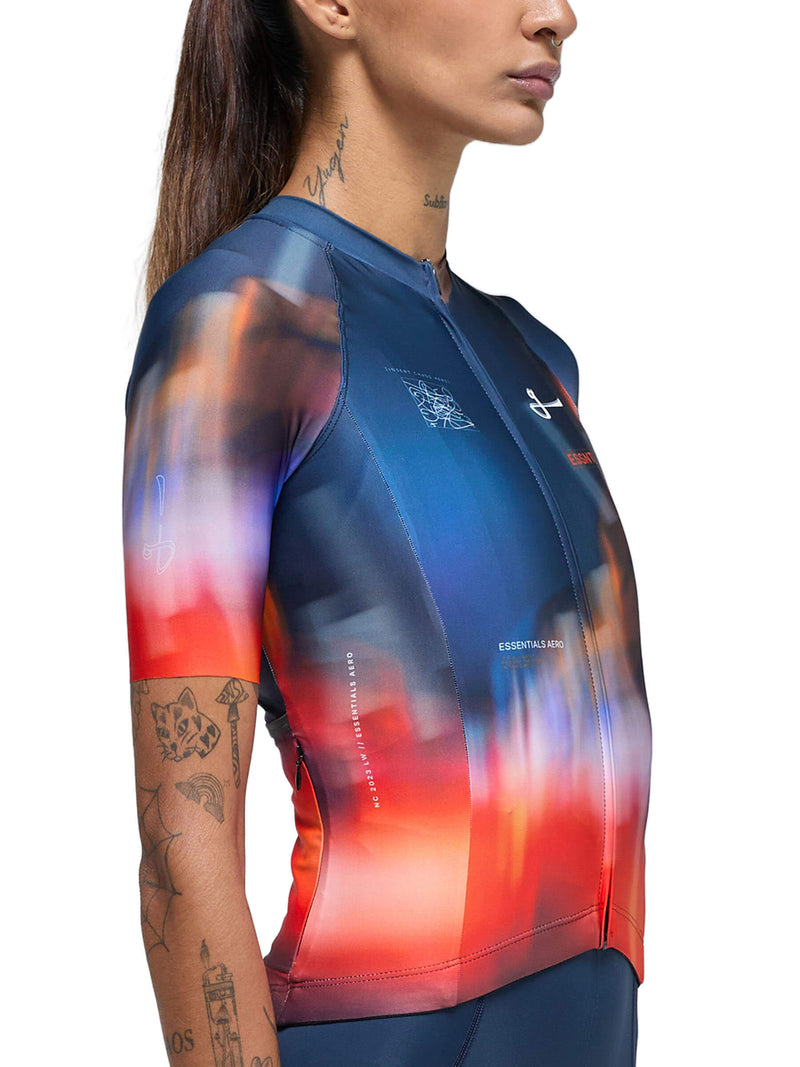 Side view of a cyclist wearing the Givelo Essentials Chaos jersey with a red to blue gradient.