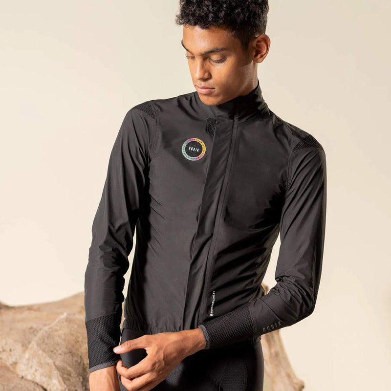 Cyclist in the EXO Royal Black jacket, demonstrating the waterproof and windproof features and snug fit.