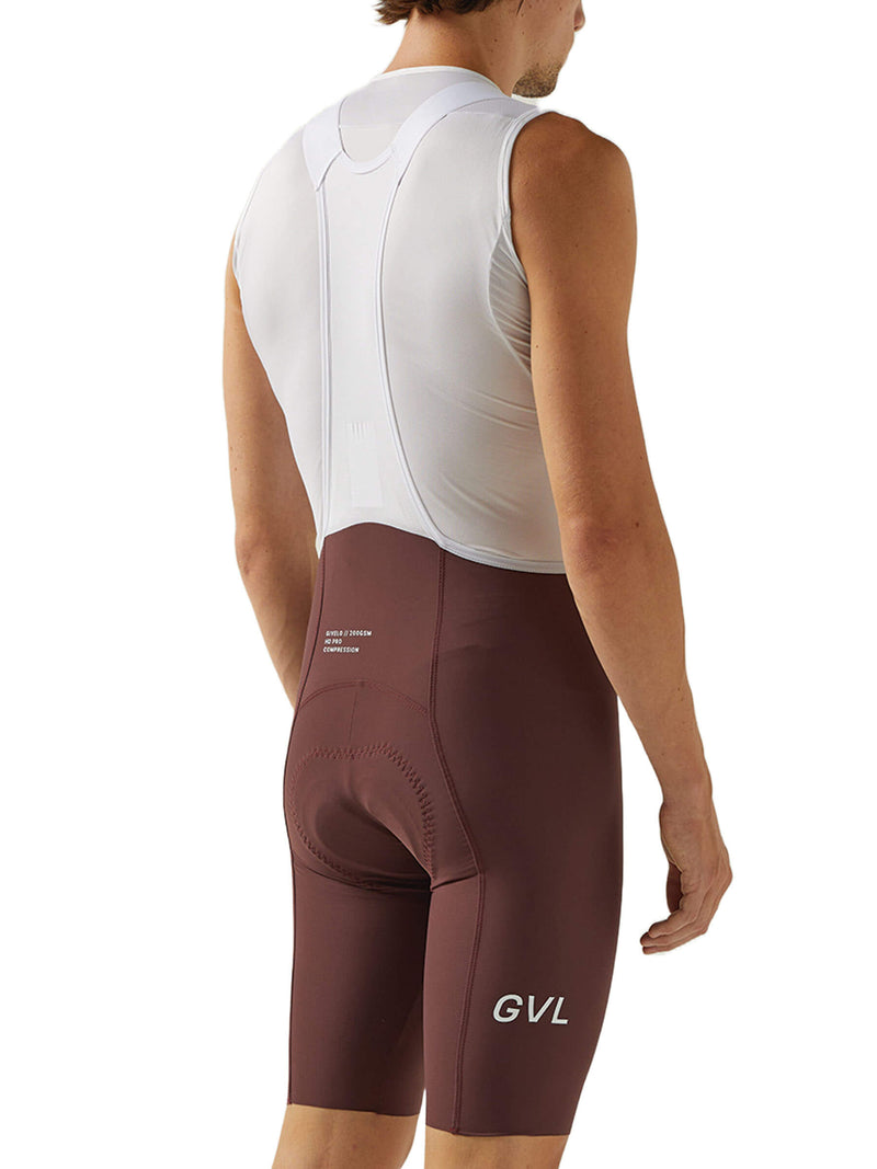 Back view of merlot-colored Givelo HD Pro Bib Shorts on a man. The shorts have a contoured design with padding and subtle branding, optimized for endurance cycling and providing support for rides lasting more than 8 hours.