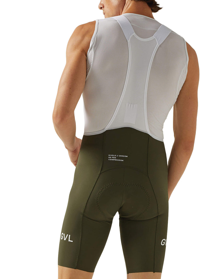 Rear view of a man wearing olive green Givelo HD Pro Bib Shorts. The design features integrated padding and compression for support during long-duration cycling. The Givelo logo is displayed on the leg and the shorts are tailored for a comfortable, aerodynamic fit.