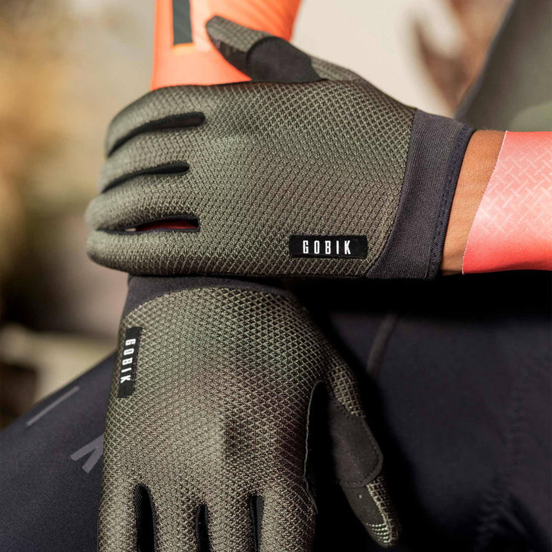 Close-up of a cyclist wearing GOBIK Lynx Gloves in army green, demonstrating grip on bike handles.
