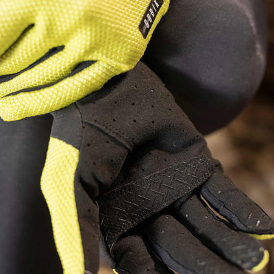 Citronell yellow GOBIK Lynx Gloves worn by a cyclist, emphasizing the fit and grip on the handlebars.