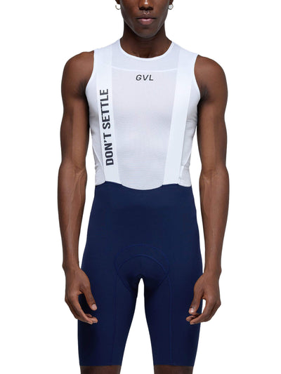 Front view of the man standing straight, showcasing the full design of the white bib shorts with the Givelo logo and navy blue cycling shorts.