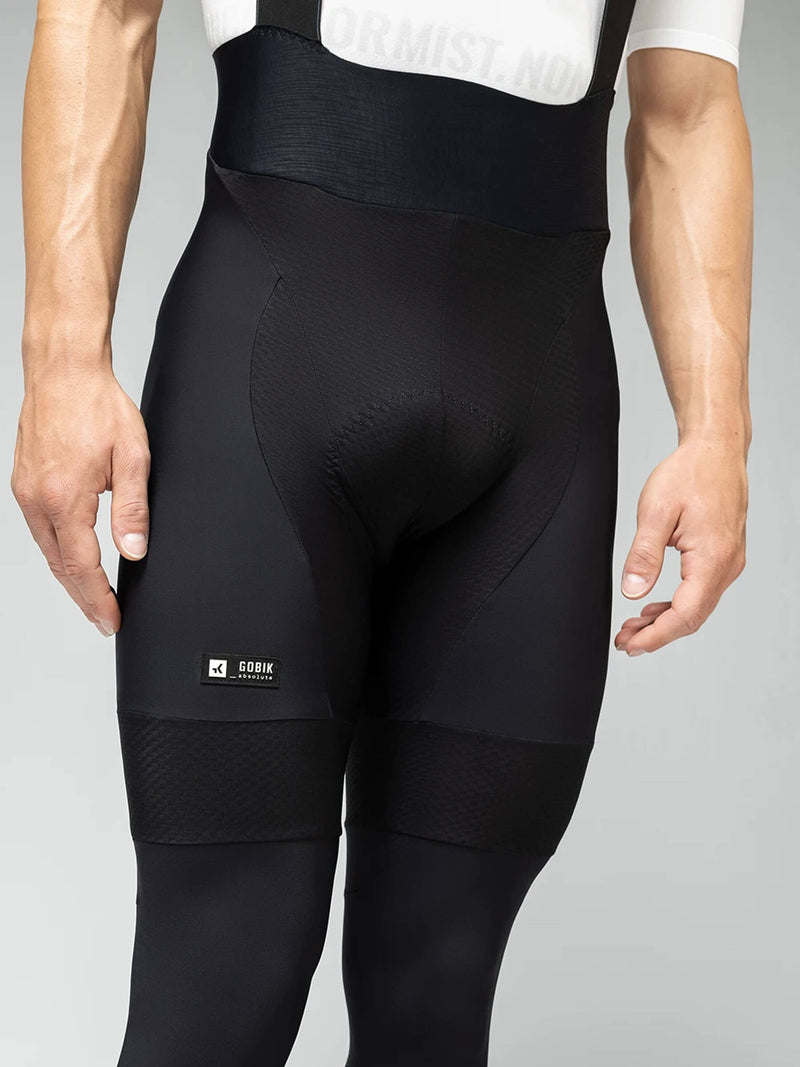 Wearing GOBIK Absolute 6.0 Bib Tights: A male cyclist models the black tights paired with a white top, showing the fit and design.