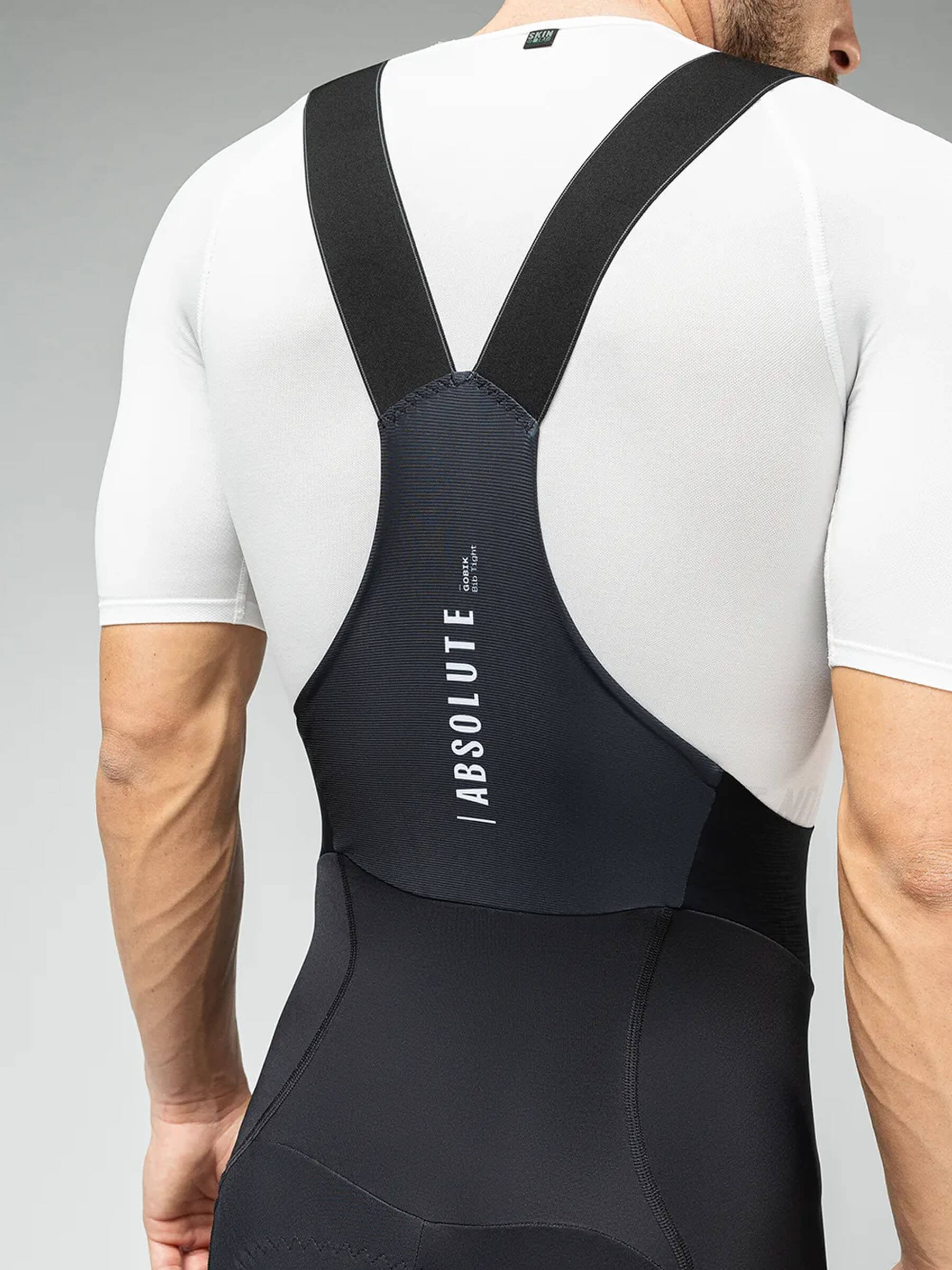 Wearing GOBIK Absolute 6.0 Bib Tights: A male cyclist models the black tights paired with a white top, showing the fit and design.