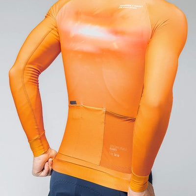 Rear view of a man in a cheddar-colored GOBIK Hyder jersey, with back pockets and side mesh for essentials.