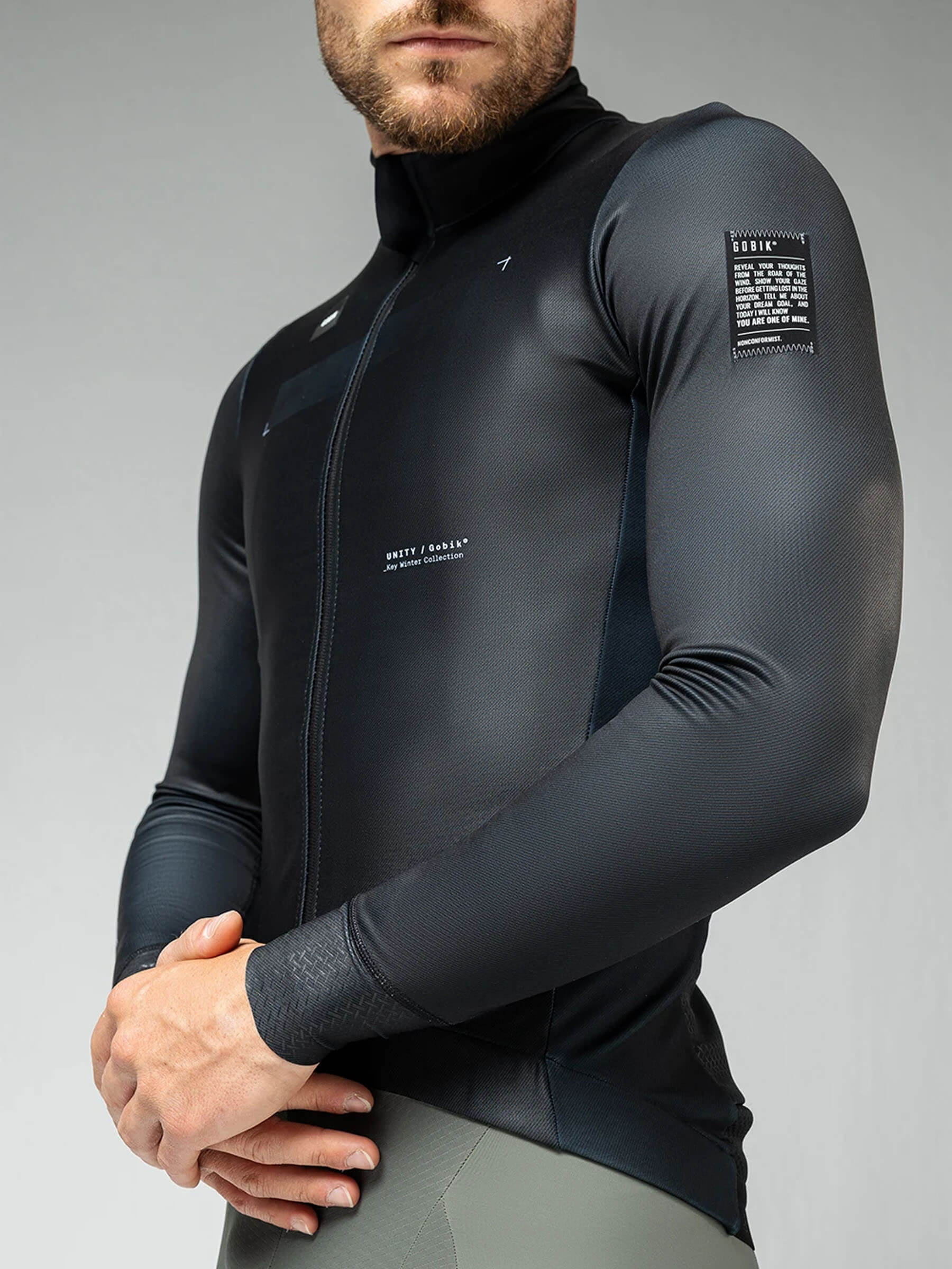 Profile view of GOBIK Skimo Pro men's jacket in black, showcasing rear pockets with GRS system and interior mesh pocket for essentials.