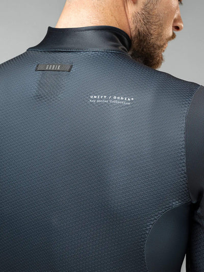 Profile view of GOBIK Skimo Pro men's jacket in black, showcasing rear pockets with GRS system and interior mesh pocket for essentials.