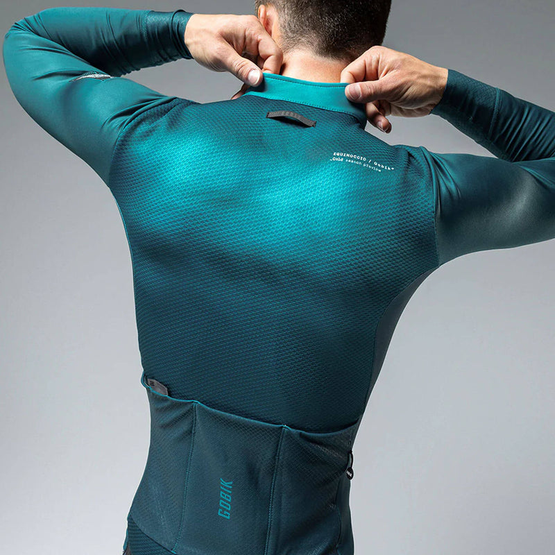 Rear view of GOBIK Skimo Pro Hydro jacket in teal, with reflective details and three back pockets for storage during low temperatures.
