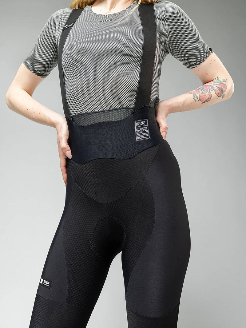 Close-up on GOBIK Black Bib Tights: A cyclist adjusts the mesh back panel, displaying the fit and quality of the material.