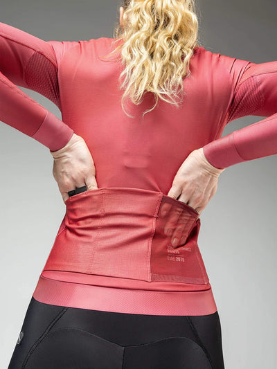 Close-up of a woman's back wearing an amaranth red Hyder jacket with accessible back pockets for storage during rides.