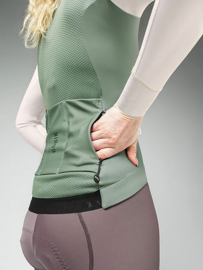 Close-up of woman in SKIMO green thermal jacket, breathable with rear pockets, for layering in 0-12C weather cycling