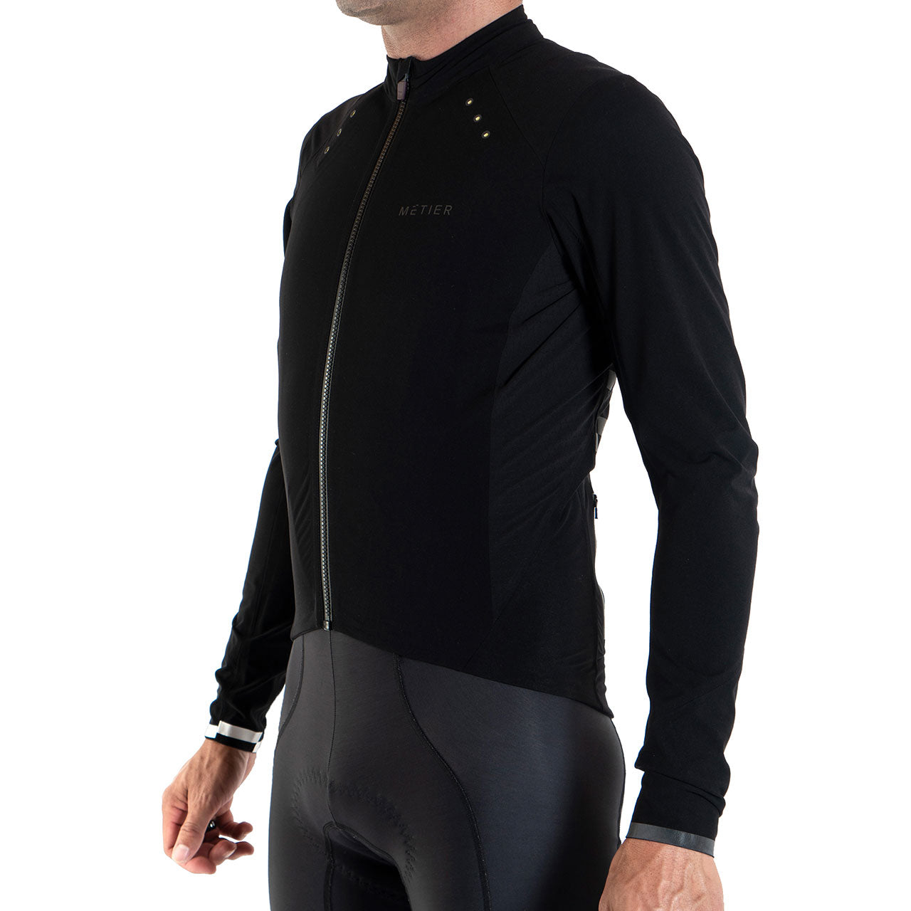Male model wearing a black Metier Beacon Jacket, a performance cycling jacket with integrated wearable LED technology.