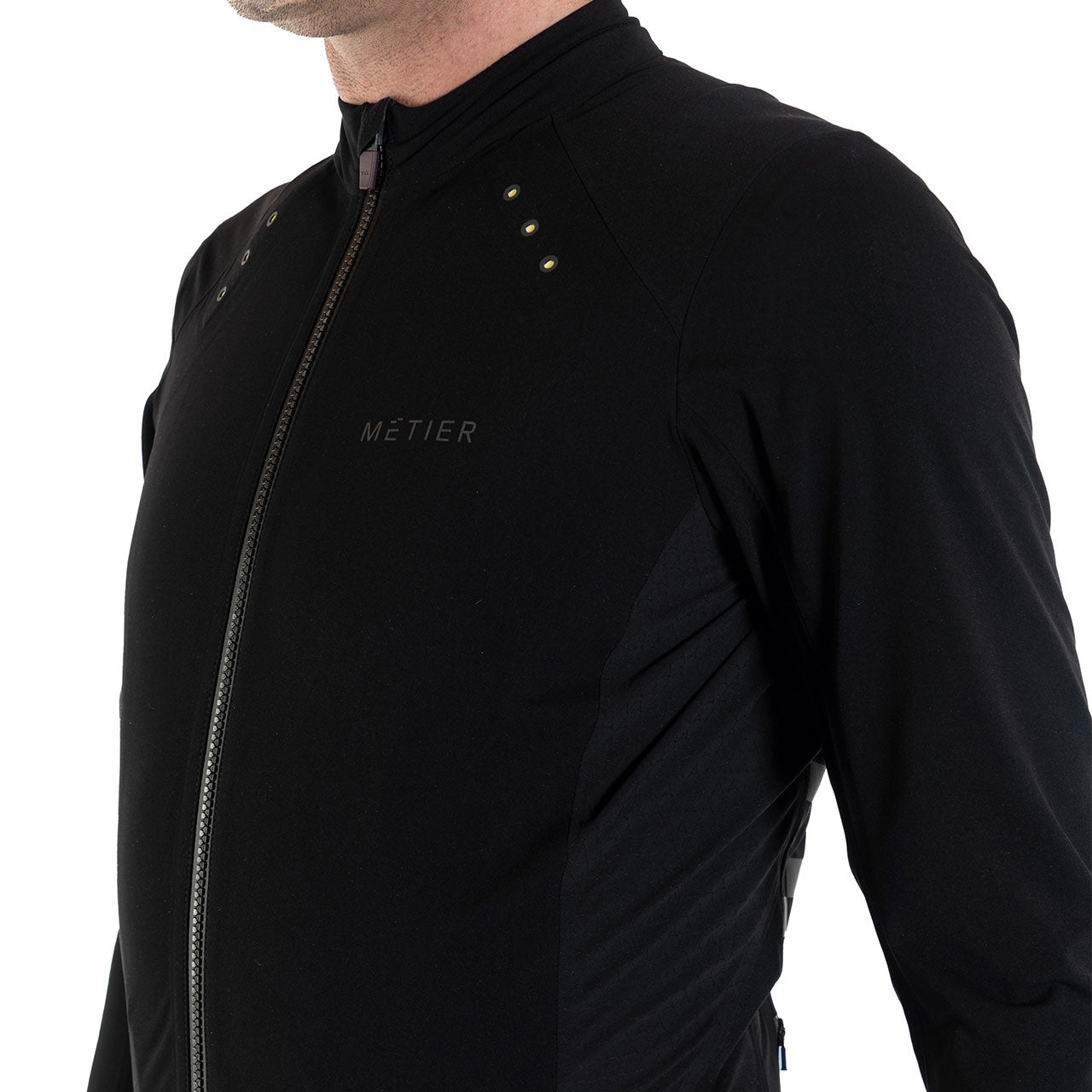 Close-up of Metier Beacon Jacket in black, featuring a front zipper and integrated LED technology for cycling performance.