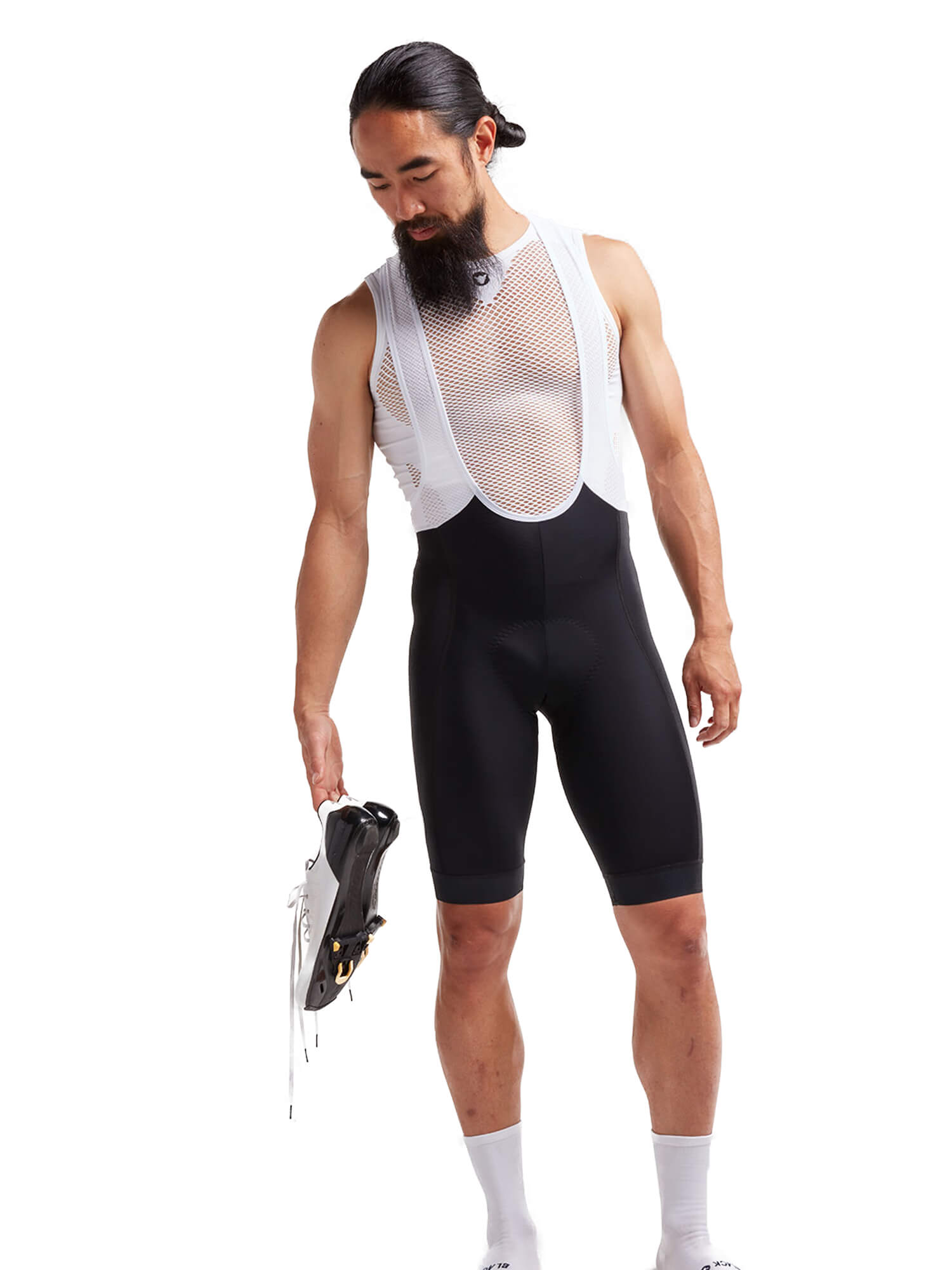 Male model wearing Black Sheep Cycling Essentials TEAM Bib - Men's black cycling shorts with white mesh straps holding a cycling shoe